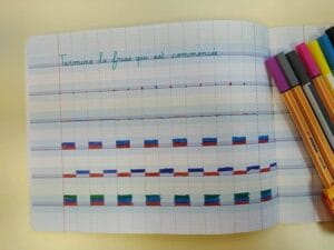 photo d'une page de cahier qui présente des exercices que l'on peut proposer pour apprendre à repérer les interlignes d'un cahier pour apprendre à écrire en attaché ensuite