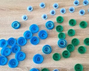 Des lettres sont écrites sur des bouchons en plastique pour aider les enfants à différencier à travailler la confusion entre le b et le d 